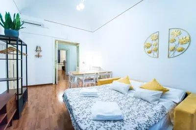 a living room with a bed and a dining room at Tibullo House in Rome