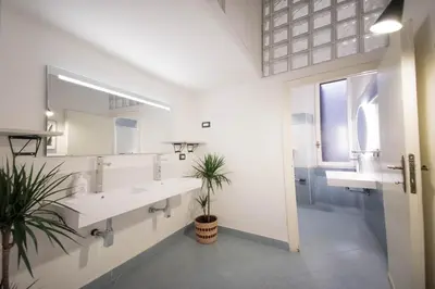 a bathroom with two sinks and a large mirror at Tibullo House in Rome