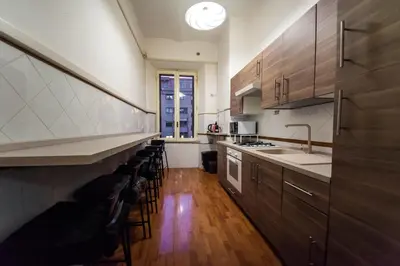 a kitchen with wooden cabinets and a counter top at Tibullo House in Rome