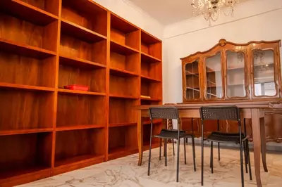 a dining room with wooden shelves and a table and chairs at Fleming in Rome