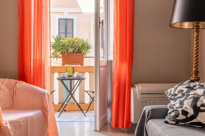 a living room with orange curtains and a chair and a table at Trastevere comfort 2 camere 2 bagni in Rome