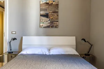 a bedroom with a bed with two lamps and a painting at Trastevere comfort 2 camere 2 bagni in Rome