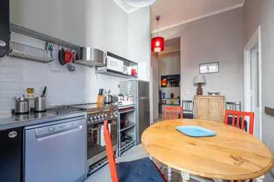 a kitchen with a wooden table and a kitchen with a stove and refrigerator at Trastevere comfort 2 camere 2 bagni in Rome