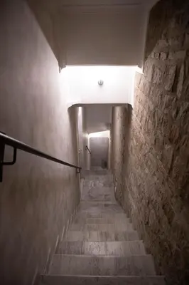 a stairway with a light at the end of a tunnel at Domus Augustea - 2 Floor in Rome