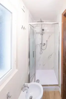 a white bathroom with a shower and a sink at Domus Augustea - 2 Floor in Rome