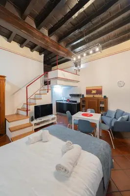 a room with a bed and a kitchen and a staircase at Sweet Rhome Navona Loft Centro Storico in Rome