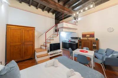 a living room with a staircase and a table and chairs at Sweet Rhome Navona Loft Centro Storico in Rome