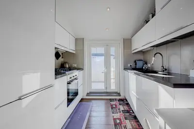 a white kitchen with white cabinets and a doorway at Casa Doni Roma in Rome