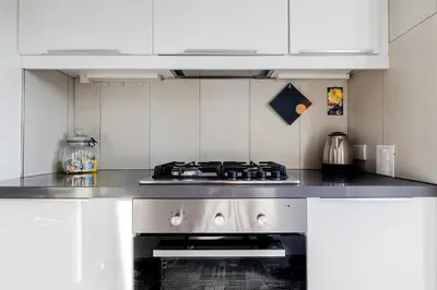 a kitchen with a stove and white cabinets at Casa Doni Roma in Rome