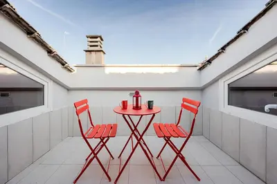 a red table and two chairs on a balcony at Casa Doni Roma in Rome