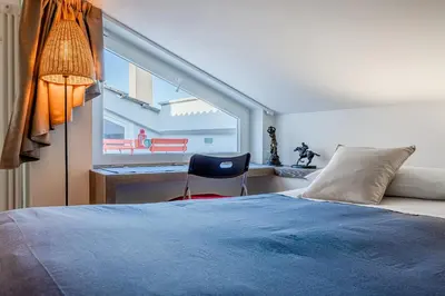 a bedroom with a bed and a desk and a window at Casa Doni Roma in Rome