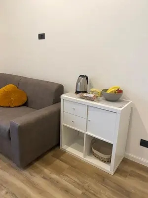 a couch and a table with a bowl of fruit on it at House of Wonders in Rome