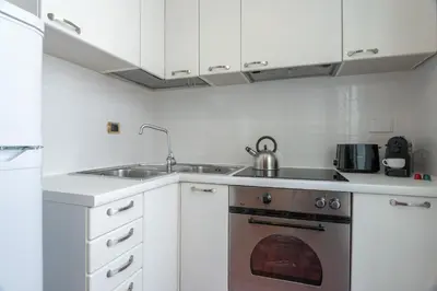 a kitchen with white cabinets and an oven at Casa Novecento Prati in Rome