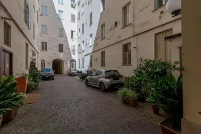 a street with cars parked in an alley between buildings at Casa Novecento Prati in Rome
