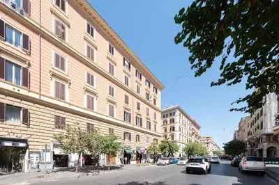 a city street with cars parked in front of a building at Casa Novecento Prati in Rome