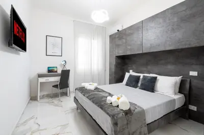 a bedroom with a large bed and a desk at Picorini House in Rome