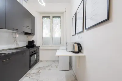 a kitchen with white walls and a table with a microwave at Picorini House in Rome