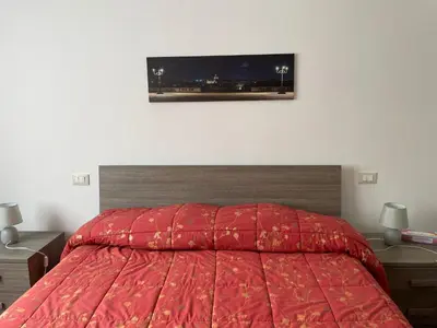 a bedroom with a red bed with a red comforter at Comfort a 7 fermate dal Colosseo in Rome