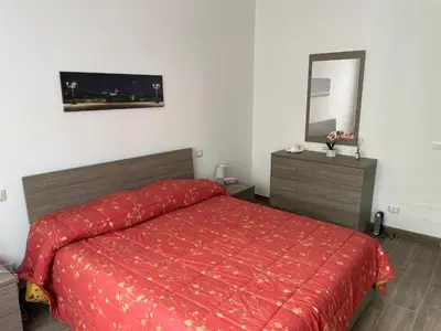 a bedroom with a red bed and a mirror at Comfort a 7 fermate dal Colosseo in Rome