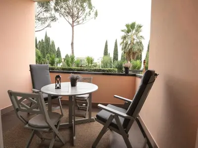 a table and chairs on a balcony with a view of trees at Vatican City Green Apartment in Rome
