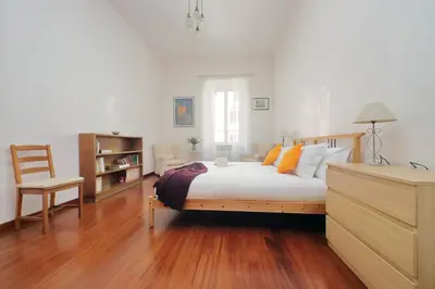 a bedroom with a bed and a chair in it at FM Apartment in Rome