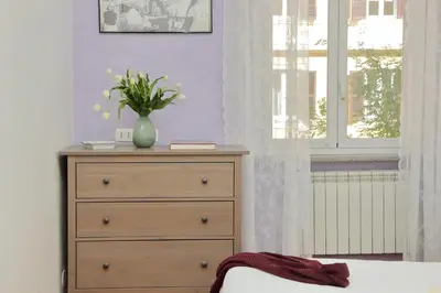a bedroom with a dresser and a vase with flowers on it at FM Apartment in Rome