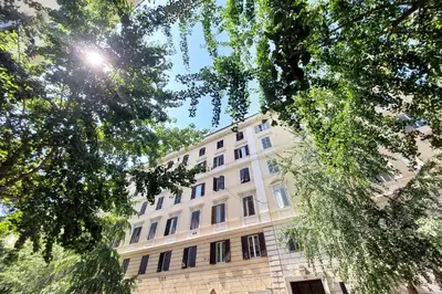 a large white building with trees in front of it at FM Apartment in Rome