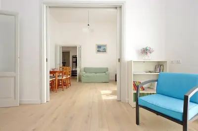 a living room with a blue chair and a table at FM Apartment in Rome