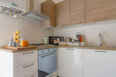 a kitchen with white cabinets and a blue oven at Stella Luxury House in Rome