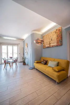 a living room with a yellow couch and a table at Tiber House 60 Rome Marconi - Rome Vacation M&D in Rome