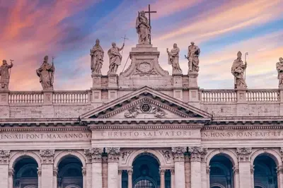 a building with statues on top of it at sunset at Alessandro Luxury Home Rome in Rome