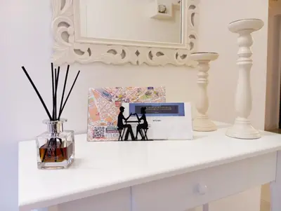 a white shelf with a picture and a vase with sticks at Alessandro Luxury Home Rome in Rome