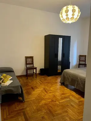a room with two beds and a wooden floor at MySweetHome near the Vatican in Rome