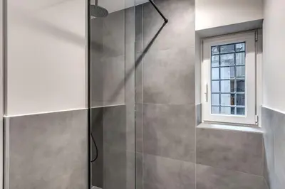 a shower with a glass door and a window at Suite Orsoline Spanish steps in Rome