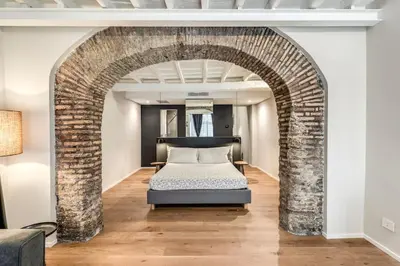 a bedroom with a bed in a brick archway at Suite Orsoline Spanish steps in Rome