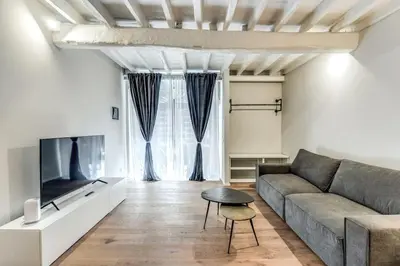a living room with a couch and a tv at Suite Orsoline Spanish steps in Rome