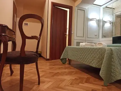 a bedroom with a chair and a bed and a mirror at Domina Popolo in Rome