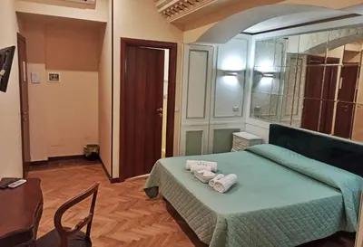 a bedroom with a green bed with towels on it at Domina Popolo in Rome