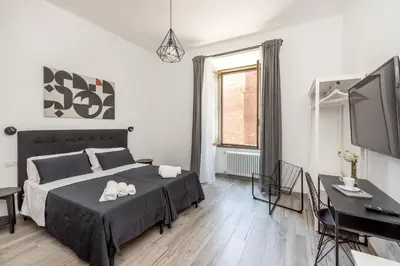 a bedroom with a bed and a desk and a television at Retro Flat Termini in Rome