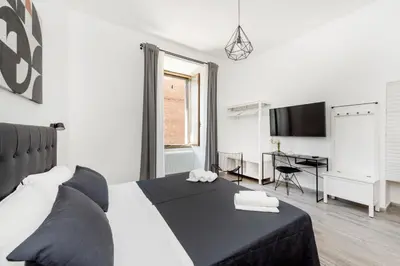 a bedroom with a bed and a desk and a television at Retro Flat Termini in Rome