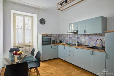a kitchen with white cabinets and a glass table at Domus Alberico 11 (Vaticano) in Rome