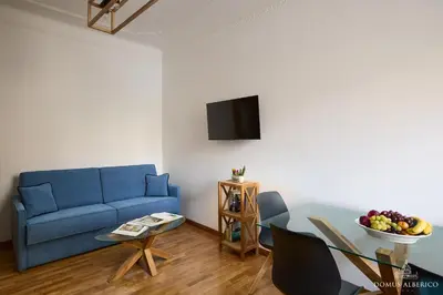 a living room with a blue couch and a table at Domus Alberico 11 (Vaticano) in Rome