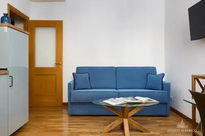 a blue couch in a living room with a table at Domus Alberico 11 (Vaticano) in Rome