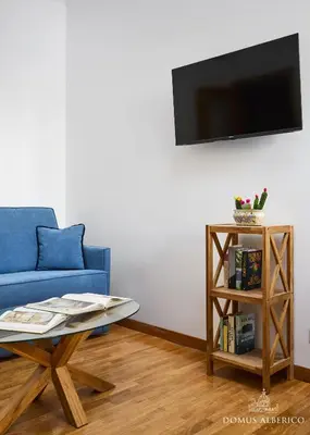 a living room with a blue couch and a table at Domus Alberico 11 (Vaticano) in Rome
