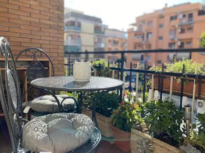 a table and chairs on a balcony with plants at Semini di nostalgia in Rome