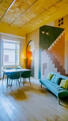 a living room with a couch and a stair mural at Charme Retreat Boki in Rome