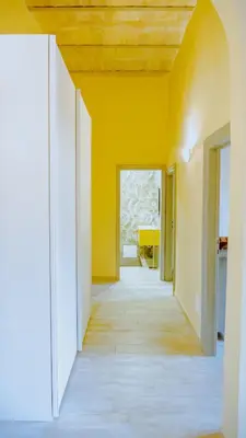 an empty hallway with yellow walls and a wooden ceiling at Charme Retreat Boki in Rome