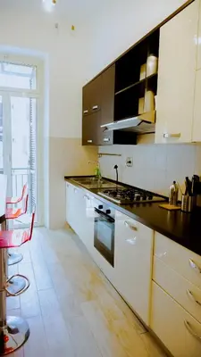 a kitchen with white cabinets and a stove top oven at Charme Retreat Boki in Rome