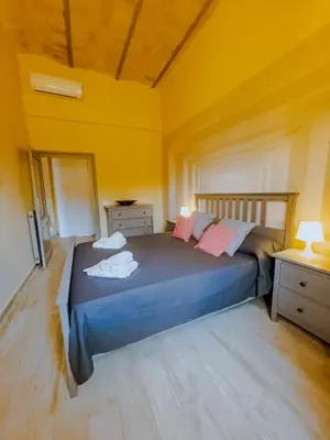 a bedroom with a blue bed with yellow walls at Charme Retreat Boki in Rome