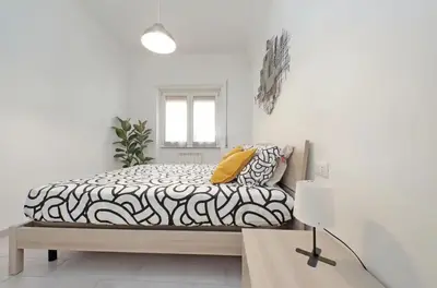 a bedroom with a bed with a black and white comforter at La Casa di Carmine in Rome